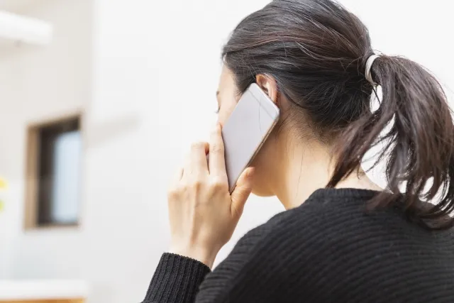 電話をかける中年女性